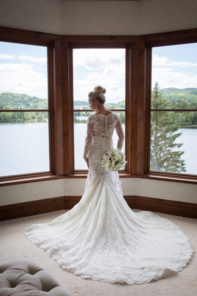 Montreal wedding photographer at hotel Quintessence bride in window facing lake tremblant