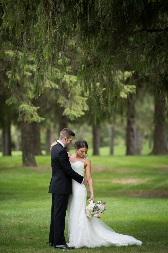 Bride and groom portrait in the forest with greenery all around them in Montreal